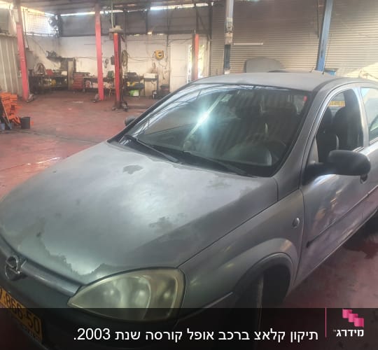 מוסך עם רכב אפור, כלי עבודה ומתקני הרמה